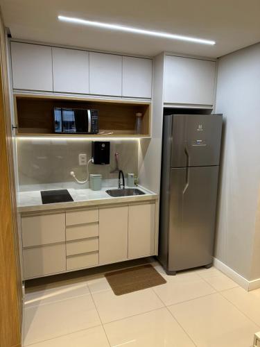 a kitchen with a sink and a refrigerator at Flat Number One - Ponta D'areia - Ferreira Hospedagens in São Luís