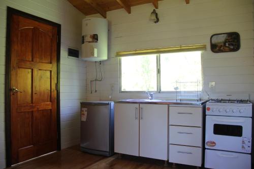 uma pequena cozinha com um lavatório e uma máquina de lavar louça em Cabaña El Mahayana em Tigre