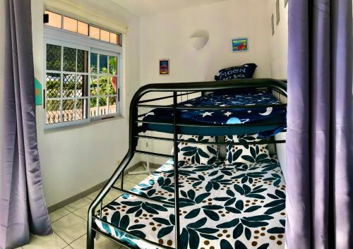 Ce dortoir comprend 2 lits superposés et une fenêtre. dans l'établissement Superbe bord de mer, accès lagon et piscine privée, à Paea