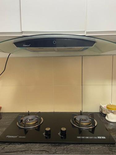 a kitchen with two burners on top of a stove at Rosnah Homestay in Kampong Ayer Resam