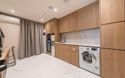 a kitchen with a washing machine in a room at Just Stay Hotel in Seoul