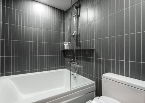 a bathroom with a tub and a toilet and a sink at Just Stay Hotel in Seoul