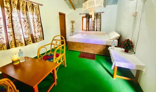 BhurkīāにあるGolden River of wild sideのベッド2台、テーブル、椅子が備わる客室です。