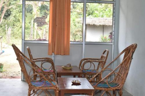 BhurkīāにあるGolden River of wild sideのテーブルと椅子、窓が備わる客室です。