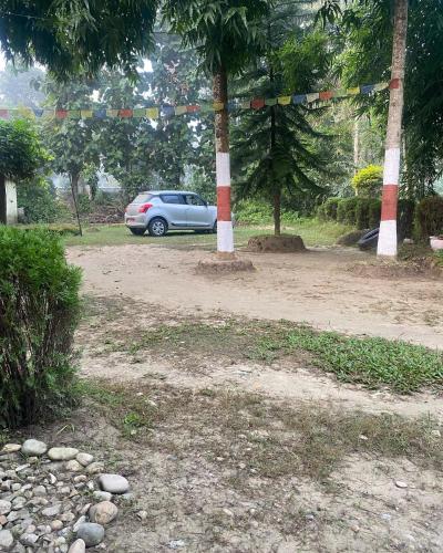 a car parked in a parking lot with trees at Bardia Wild Side Hotel in Bhurkīā