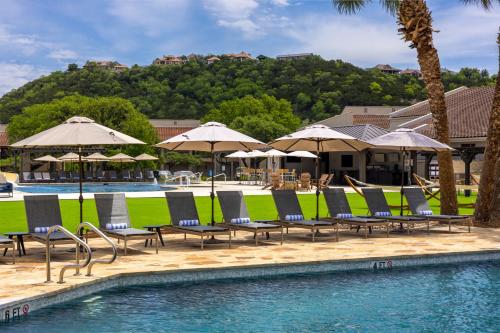 a pool with lounge chairs and umbrellas in a resort at Tapatio Springs Hill Country Resort in Boerne