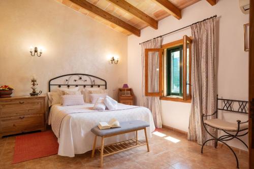 a bedroom with a bed and a chair and a window at Es Pujolet - Alcudia in Port d'Alcudia