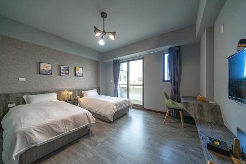 um quarto com 2 camas e uma televisão de ecrã plano em Park Oasis em Tainan