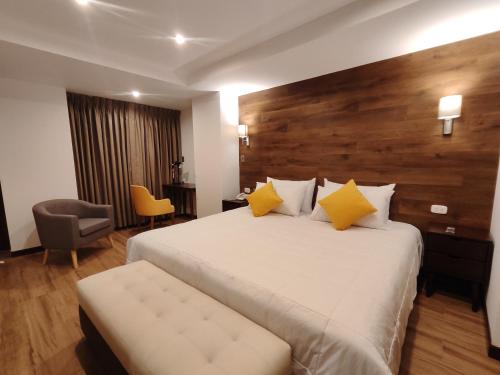 a hotel room with a large bed with yellow pillows at LA TERRAZA INN in Huancavelica