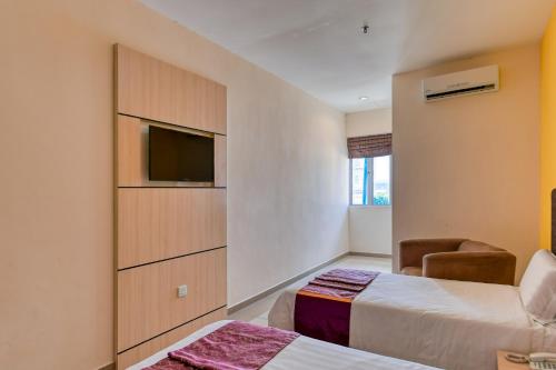 a hotel room with two beds and a flat screen tv at Geopark Hotel Kuah Langkawi in Kuah