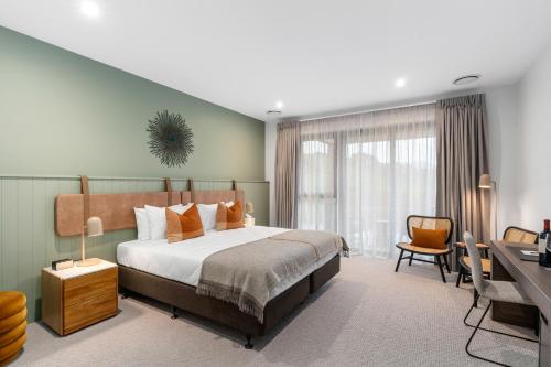 a hotel room with a bed and a desk and a desk at Te Karaka Lodge in Port Waikato