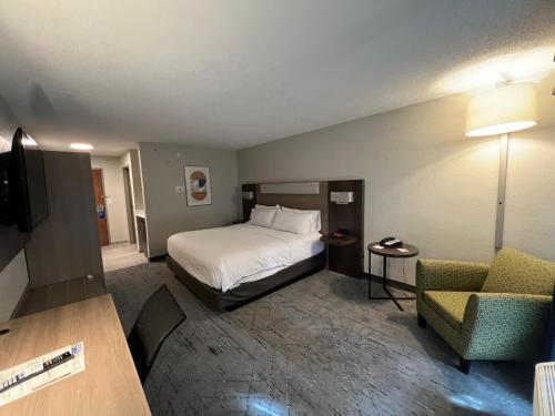 um quarto de hotel com uma cama e uma cadeira em Holiday Inn Express Hotel & Suites Dubois, an IHG Hotel em DuBois
