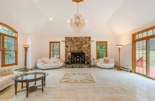 a large living room with a fireplace and a chandelier at Villa Verde B&B, Greenwood Lake, NY in Monroe
