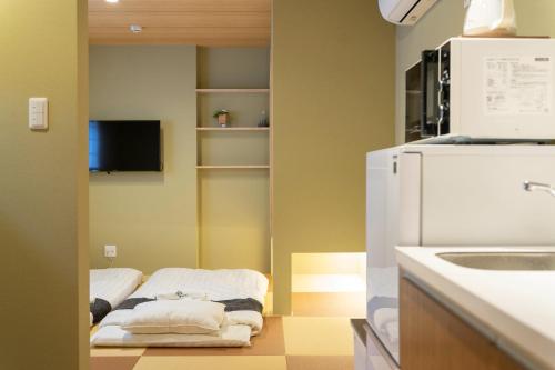 a kitchen with a white refrigerator and a sink at HANASTAY花渓居 · 梨（NASHI) in Osaka