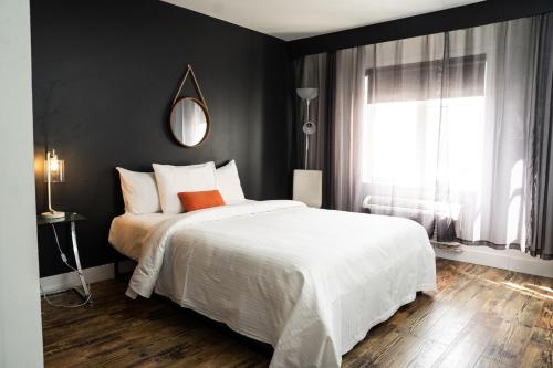 a bedroom with a large white bed and a window at Hôtel Énergie Shawinigan in Shawinigan