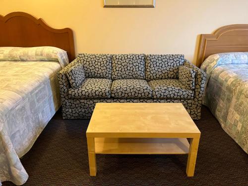 a room with a couch and a bed and a table at Fairview Inn in Simcoe