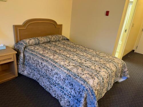 a hotel room with a bed and a table at Fairview Inn in Simcoe