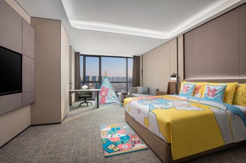 a hotel room with a yellow bed and a television at Crowne Plaza Zhengzhou High Tech Zone by IHG in Zhengzhou