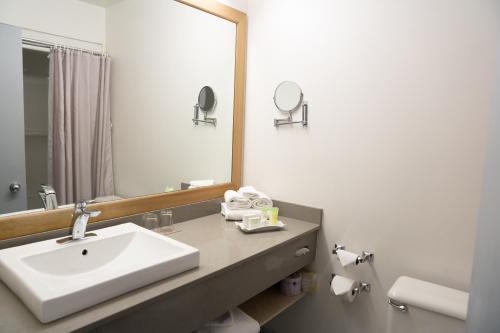 a bathroom with a sink and a mirror at Hôtel Énergie Shawinigan in Shawinigan
