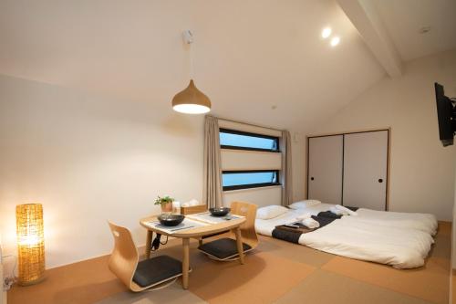 sypialnia z łóżkiem, stołem i krzesłami w obiekcie HANASTAY花渓居 · 梨（NASHI) w Osace