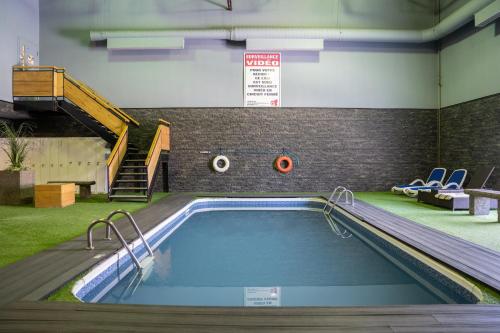 a swimming pool in a building with a slide at Hôtel Énergie Shawinigan in Shawinigan