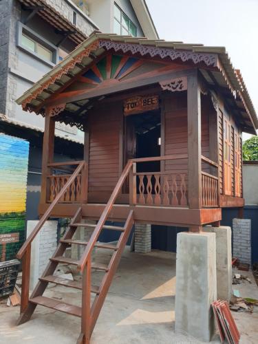 ein Holzhaus mit einem Balkon und einer Treppe in der Unterkunft Pondok Tok Bee in Bayan Lepas