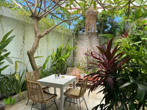 a white table and chairs in a garden at The Jungle House in Canggu