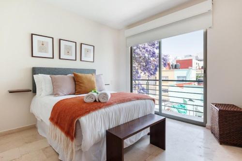 a bedroom with a bed and a large window at Urban Classic CDMX 2BD 4PAX// Céntrico con balcón in Mexico City