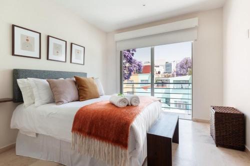 a bedroom with a bed and a large window at Urban Classic CDMX 2BD 4PAX// Céntrico con balcón in Mexico City