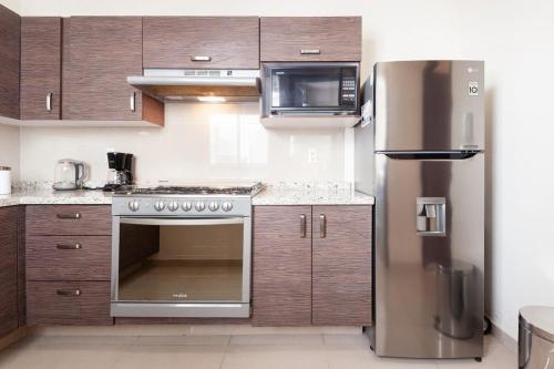 a kitchen with a stainless steel stove and refrigerator at Urban Classic CDMX 2BD 4PAX// Céntrico con balcón in Mexico City