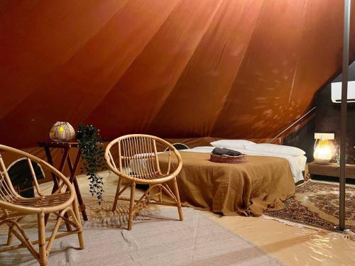 a room with two chairs and a bed in a tent at Tingkat Valley in Ipoh