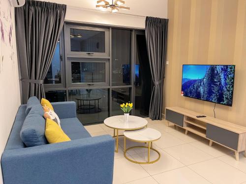 a woman laying on a blue couch in a living room at Pacific Tower Petaling Jaya Near Jaya One, University Malaya, Columbia Hospital By My Homez in Petaling Jaya