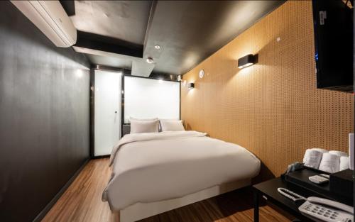 een slaapkamer met een groot wit bed en een bureau bij Shinchon Wol Hotel in Seoul
