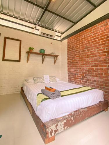 a bed in a room with a brick wall at Tingkat Valley in Ipoh