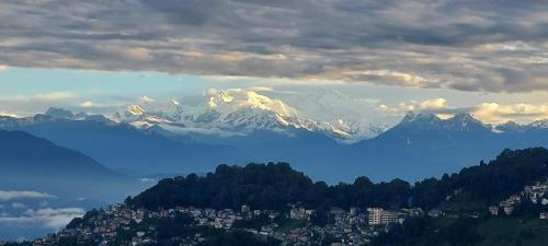 a view of a snow covered mountain with a city at Dew Drops Guest House in Darjeeling