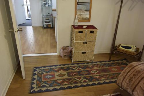 a living room with a rug and aoyer with a table and a door at EMS Enoshima クラシックゲストハウス 寝室は個室 犬OK in Fujisawa