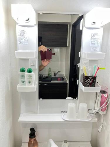a person taking a picture of a mirror in a bathroom at *301 Oshiage sta 3mins walk! Wi-Fi Elevator in Tokyo
