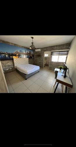 1 dormitorio con cama, escritorio y mesa en Casa IBOC, en Los Mochis