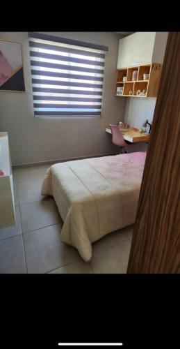 1 dormitorio con cama, escritorio y ventana en Casa IBOC, en Los Mochis