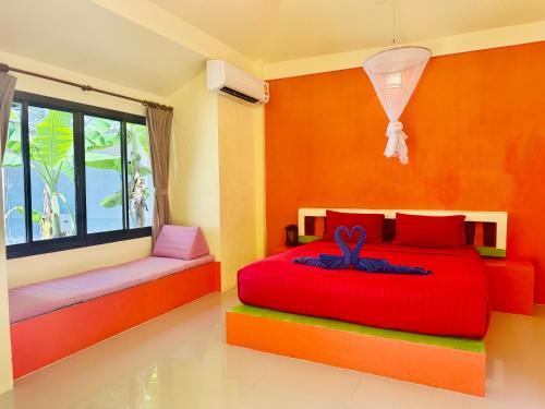 a bedroom with a red bed and a window at Da Kanda Villa Beach Resort in Thong Sala