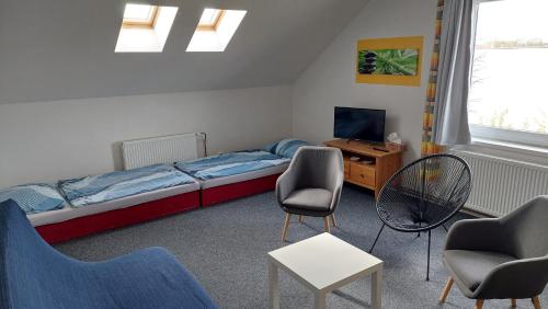 um quarto com uma cama e cadeiras e uma secretária em Apartmány Kousek od jezera em Doksy