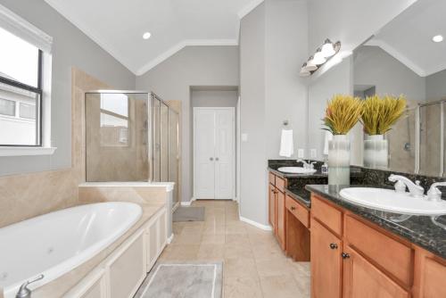 a bathroom with two sinks and a tub and a large mirror at 3BR 3Ba Upscale Luxury Home in The Heights in Houston