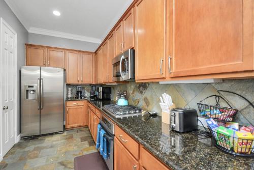 a kitchen with wooden cabinets and a stainless steel refrigerator at 3BR 3Ba Upscale Luxury Home in The Heights in Houston
