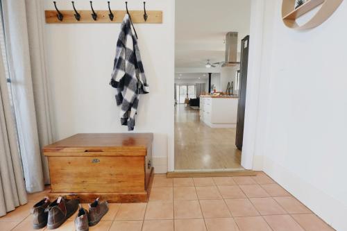 Cygnet RiverDusty's Run - Escape. Relax. Explore.的走廊里放着一个木箱，地板上散落着鞋子。