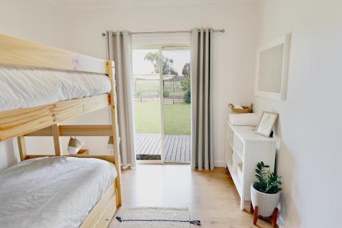 Cygnet RiverDusty's Run - Escape. Relax. Explore.的一间卧室配有双层床和滑动玻璃门