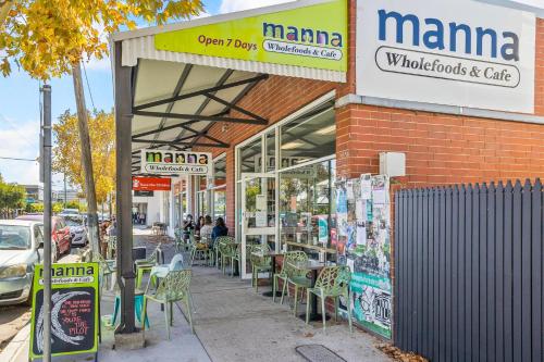 a manma store with tables and chairs on a street at All Decked Out, Fremantle in Fremantle
