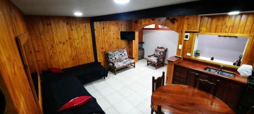 una sala de estar con sofá y lavabo en una habitación en "Antúbea" Departamento particular en San Martín de los Andes