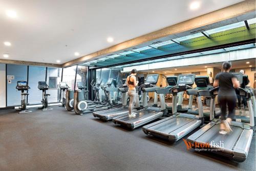 two people exercising on tread machines in a gym at Sakura Apartment in Melbourne