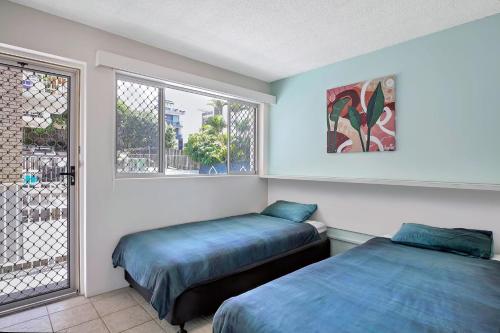 a bedroom with two beds and a window at Beachcomber Unit 4 7 Dingle Ave in Caloundra
