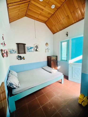 a bed in a room with a wooden ceiling at Vietnam Phuot Real Home in Kon Tum